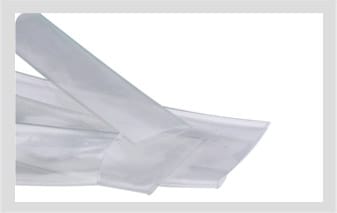 Flattened lengths of clear translucent heat-shrink sleeving overlapping on a white ground.